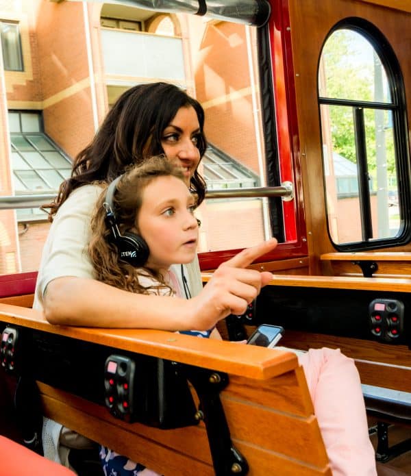 Mom and daughter with headphones on trolley tour